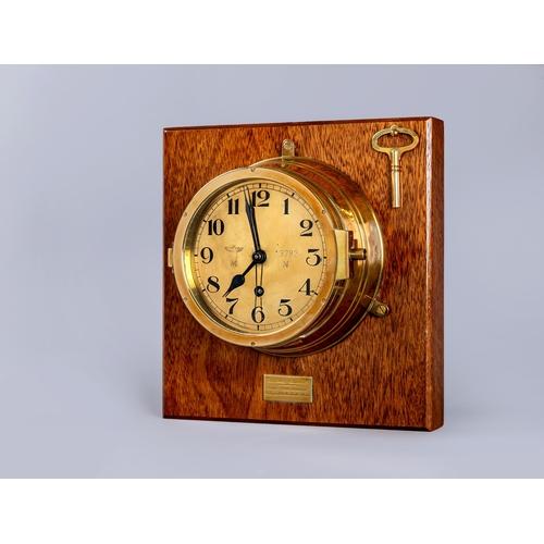 407 - A GERMAN THIRD REICH KRIEGSMARINE BRASS WALL CLOCK of bulkhead design with key opening door, brass f... 