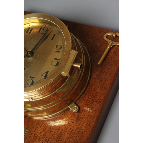 407 - A GERMAN THIRD REICH KRIEGSMARINE BRASS WALL CLOCK of bulkhead design with key opening door, brass f... 