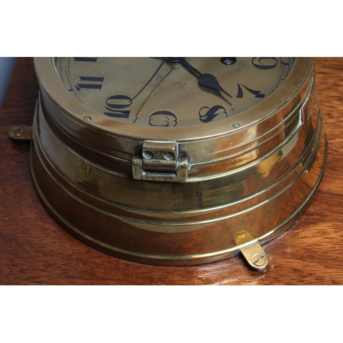 407 - A GERMAN THIRD REICH KRIEGSMARINE BRASS WALL CLOCK of bulkhead design with key opening door, brass f... 
