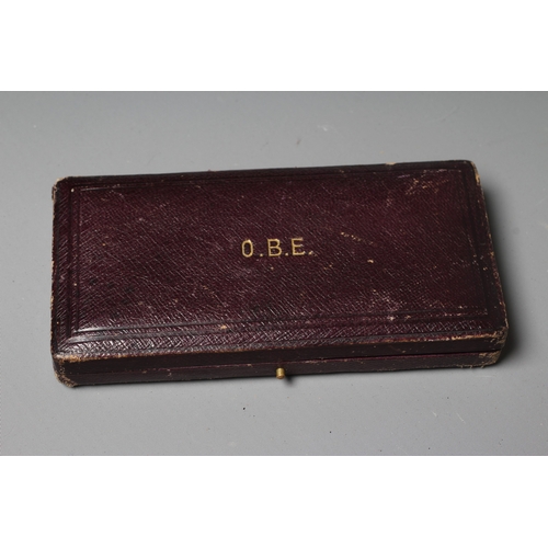438 - A SILVER OBE, London 1919, Garrard & Co. Ltd, with purple ribbon, cased