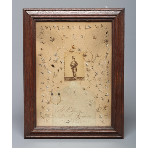 452 - A VICTORIAN FRAMED FISHING DISPLAY centred by a photograph of a gentleman in tails, top hat and fish... 