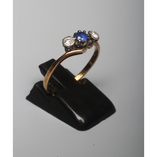 281 - A SAPPHIRE AND DIAMOND THREE STONE CROSSOVER RING, the central facet cut sapphire claw set and flank... 