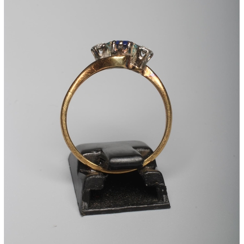 281 - A SAPPHIRE AND DIAMOND THREE STONE CROSSOVER RING, the central facet cut sapphire claw set and flank... 