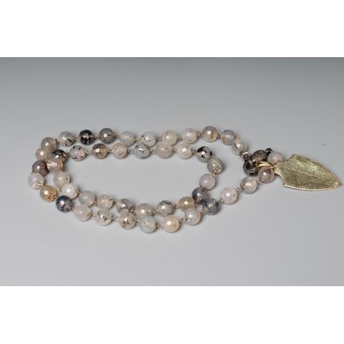 283 - A STRING OF FACET CUT MOSS AGATE BEADS, the pave set diamond lobster clasp with a cream enamel amd d... 