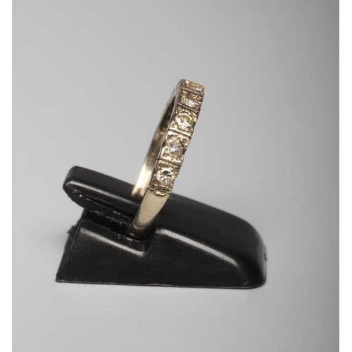 286 - A NINE STONE DIAMOND HALF HOOP ETERNITY RING, the small brilliant cut stones claw set to a plain sha... 