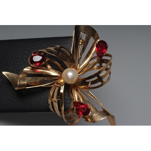 290 - A RUBY AND PEARL ABSTRACT FLOWERHEAD BROOCH, the pierced scroll petals and leaves claw set with thre... 