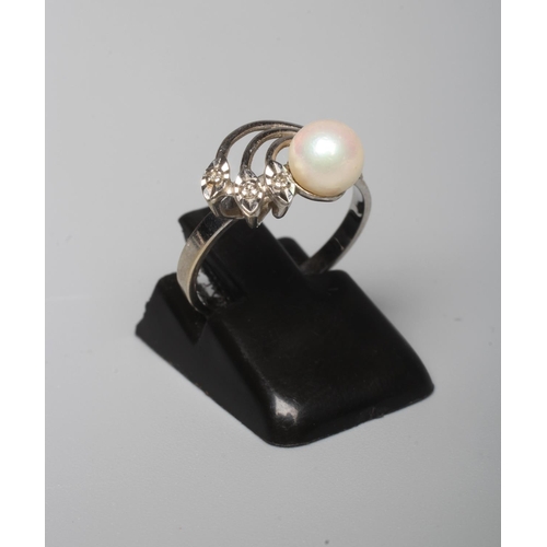 294 - A DRESS RING, peg set with a cultured pearl beside three leaves each pave set with a small diamond t... 