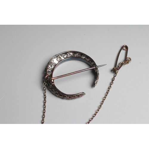 297 - A DIAMOND CRESCENT BROOCH, the seventeen old brilliant and four rose cut graduated stones claw set t... 