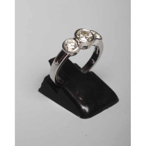299 - A THREE STONE DIAMOND RING, the central round brilliant cut stone open back collet set and flanked b... 