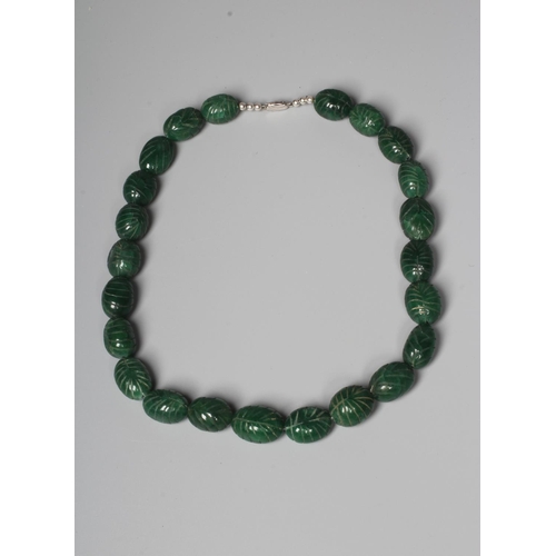 302 - A STRING OF GRADUATED CARVED OVAL GREEN ONYX BEADS with silver clasp