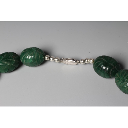 302 - A STRING OF GRADUATED CARVED OVAL GREEN ONYX BEADS with silver clasp