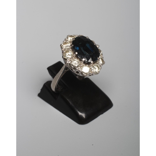 311 - A SAPPHIRE AND DIAMOND RING, the oval facet cut sapphire claw set to a border of ten brilliant cut d... 