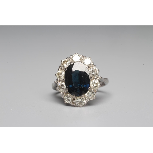 311 - A SAPPHIRE AND DIAMOND RING, the oval facet cut sapphire claw set to a border of ten brilliant cut d... 