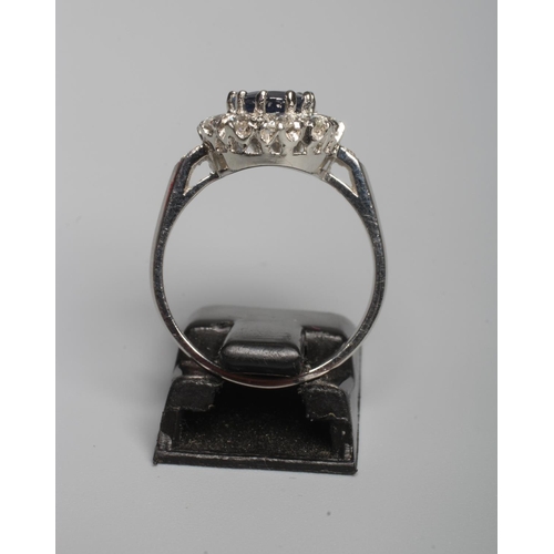 316 - A SAPPHIRE AND DIAMOND CLUSTER RING, the oval facet cut sapphire of approximately 1.50cts, claw set ... 