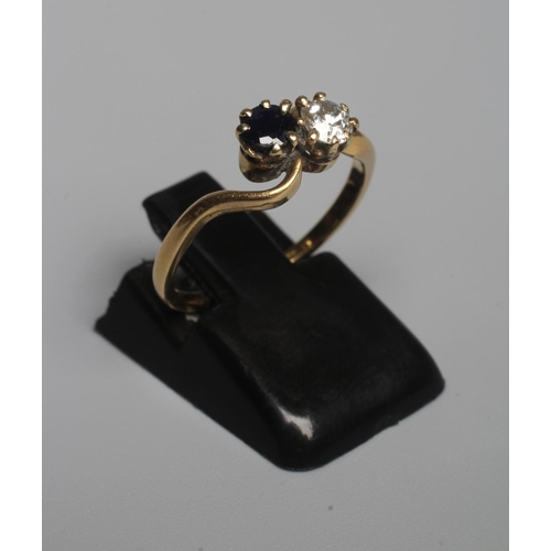 326 - A TWO STONE SAPPHIRE AND DIAMOND CROSSOVER RING, both stones claw set to a plain shank, indistinctly... 