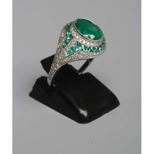 327 - AN ART DECO STYLE EMERALD AND DIAMOND COCKTAIL RING, the central oval facet cut emerald of 1.37cts, ... 