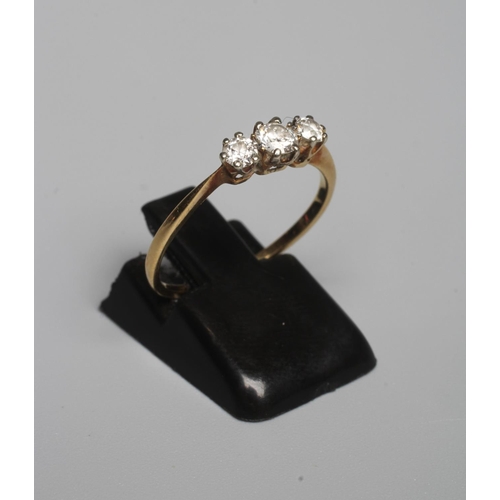 328 - A THREE STONE DIAMOND RING, the graduated stones claw set to a plain shank, indistinctly stamped 18c... 