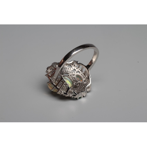 329 - A THREE STONE OPAL DRESS RING, the oval cabochon polished stones claw set to a fancy open frame set ... 