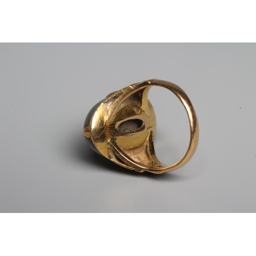 343 - A CHINESE RING, the oval cabochon polished jade panel claw set to stepped shoulders and a plain gold... 