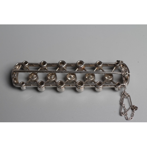 345 - AN ART DECO DIAMOND BROOCH of D end oblong form centred by a lattice with seventeen diamonds collet ... 