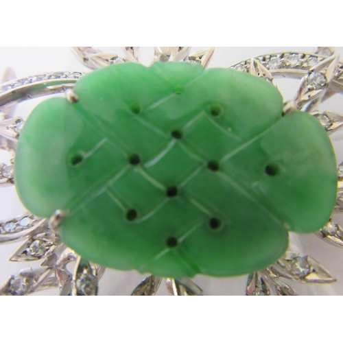 277 - A DIAMOND AND JADE FLOWER SPRAY BROOCH, the central quatrefoil jade panel incise carved and dot pier... 