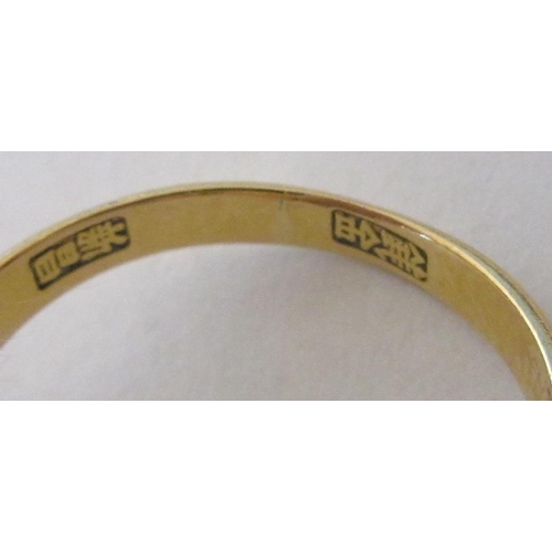 343 - A CHINESE RING, the oval cabochon polished jade panel claw set to stepped shoulders and a plain gold... 