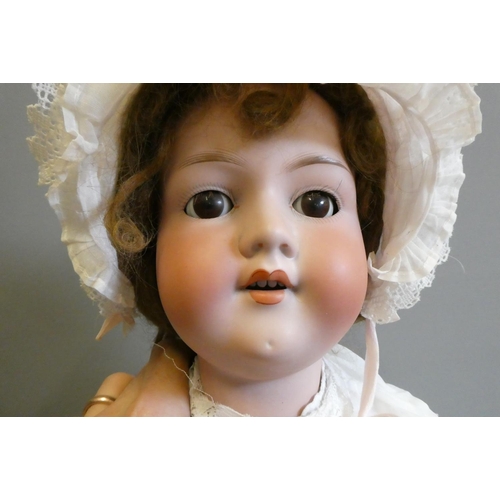 101 - A large Armand Marseille bisque socket head doll, with brown glass sleeping eyes, open mouth, teeth,... 