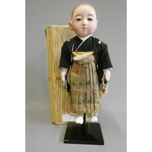 105 - A Japanese doll, with composition head, glass fixed eyes, composition lower limbs, original outfit a... 