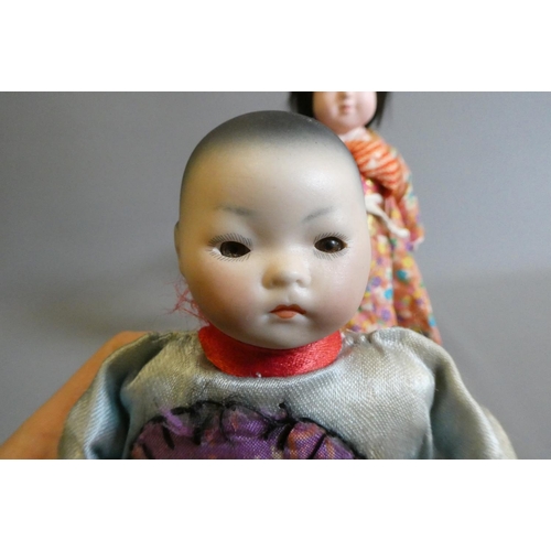 61 - Two oriental dolls comprising an 11