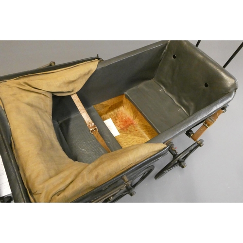 93 - A late Victorian dolls twin pram, with leatherette hood, sprung base suspended on leather straps and... 