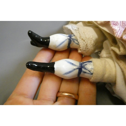 95 - A Victorian china shoulder head doll, with moulded hair, painted features, fabric body, china lower ... 