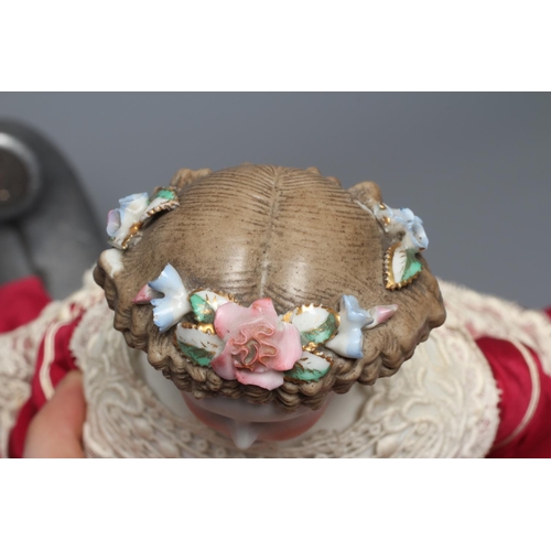 97 - A bisque shoulder head doll, possibly Dornheim, with moulded hair encrusted with flowers, painted fe... 