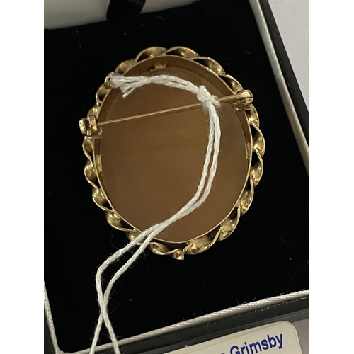 21 - Large 9ct gold cameo brooch with scrolled edging and in very good condition. Total weight is 11.2g a... 