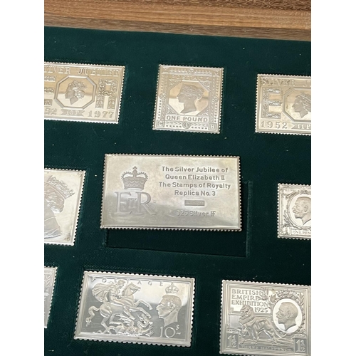 66 - STERLING SILVER STAMP SET IN AN INLAID WOODEN BOX 485. GRAMS THE STAMPS ARE OF ROYALTY