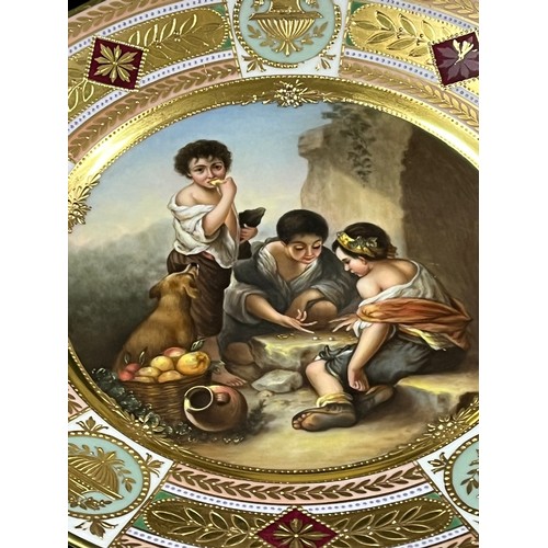 39 - A WELL PAINTED ROSENTHAL PLATE WITH A SCENE OF CHILDREN PLAYING DICE, AFTER A PAINTING BY MURILLO, T... 