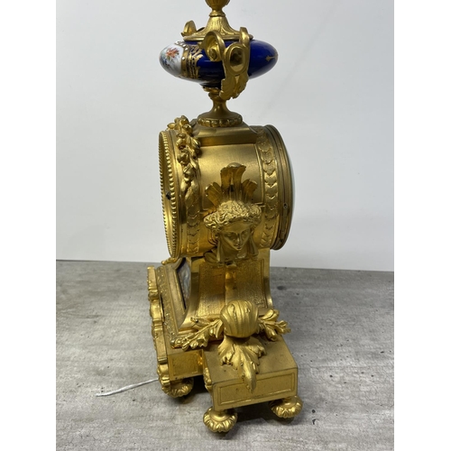 126 - A FRENCH ORMOLU CLOCK SURMOUNTED BY A PARIS PORCELAIN URN WITH ACORN FINIAL AND ACANTHUS LEAF SCROLL... 