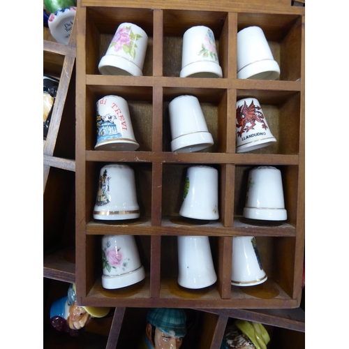 4 - A good collection of miniature character jugs and thimbles both in wooden display cases