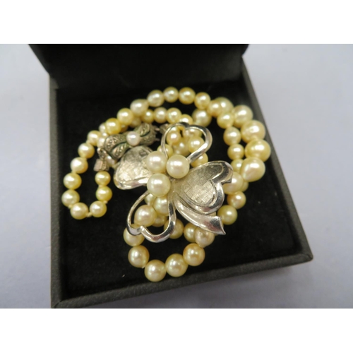 74 - A cultured graduated single string of pearls together with sterling silver four leaf clover pearl br... 