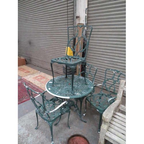 3 - Circular cast metal garden table and four chairs