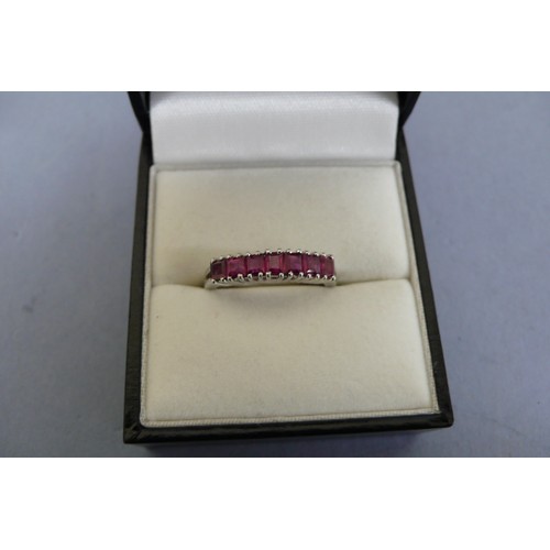 448 - 18ct white gold ruby ring set with seven square stones. Size M