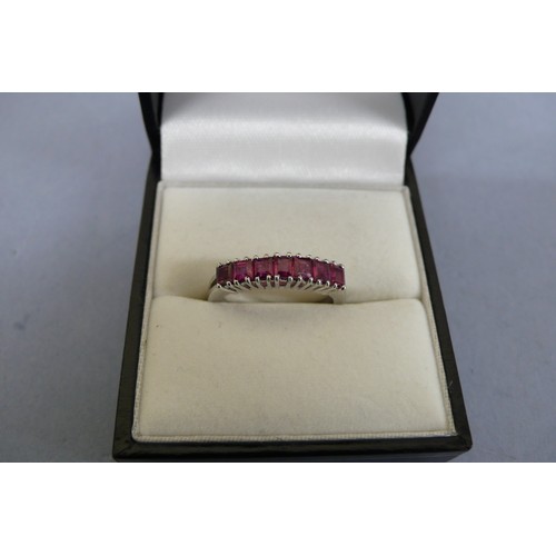 448 - 18ct white gold ruby ring set with seven square stones. Size M