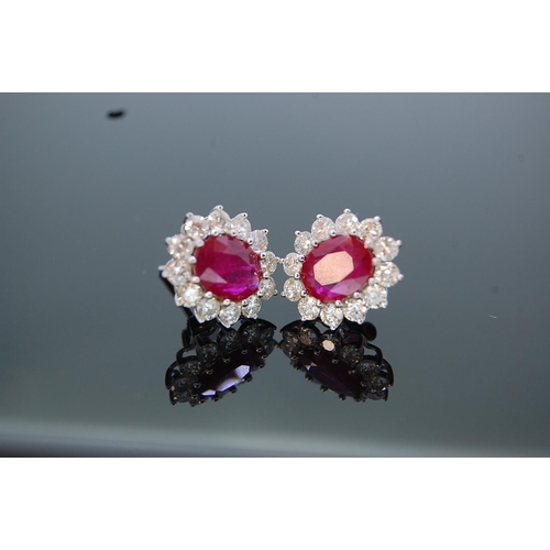 198 - Pair of large 18 ct. white gold oval ruby and diamond cluster ear studs (boxed).  Rubies 3.15 cts. t... 