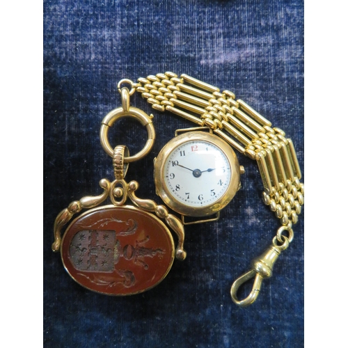 393 - A 15 ct. gold and carnelian oval swivel fob and chain together with 9ct. gold ladies wrist watch