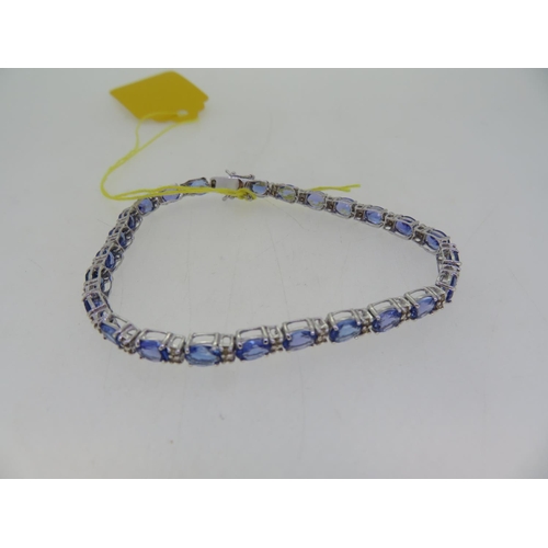 400 - 18ct white gold oval cut tanzanite and diamond line bracelet, 8.68 carats tanzanites