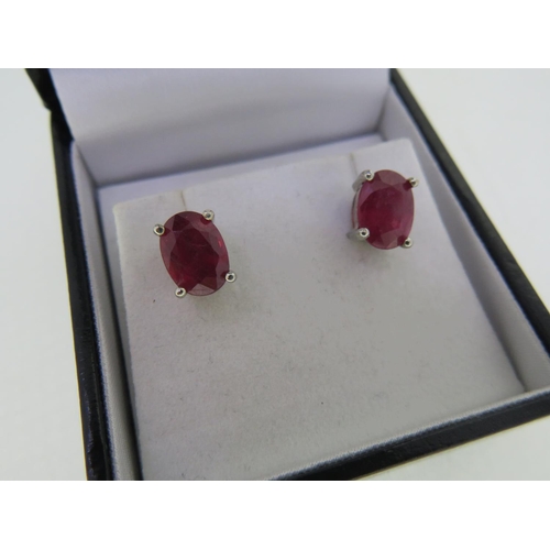 410 - Pair of treated ruby ear studs set in silver