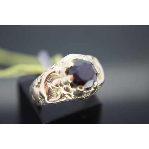 196 - Gold ring with garnet having naked women running up each side, size K