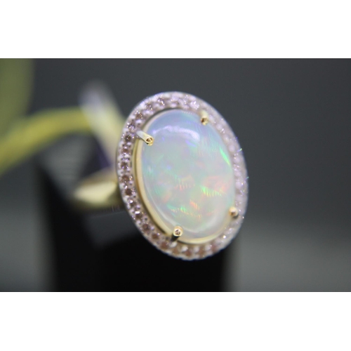 294 - 14ct yellow gold ring set with oval cabochon opal, surrounded by diamonds, 2.8ct opal, size M/N