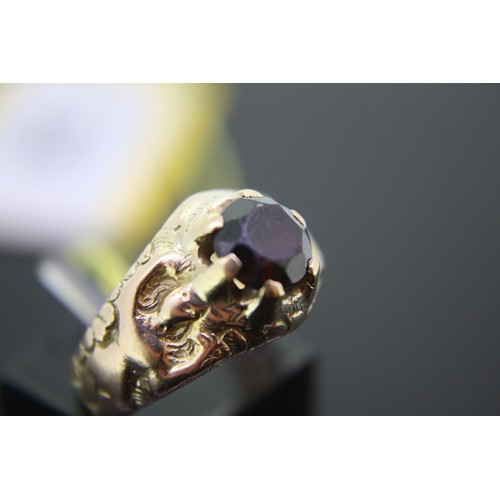 196 - Gold ring with garnet having naked women running up each side, size K