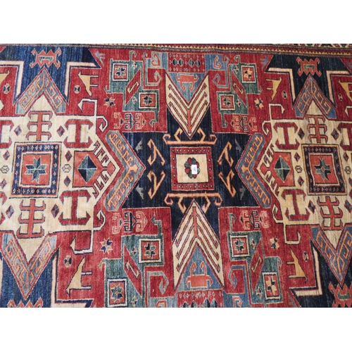 127 - Good quality carpet with geometric designs in mostly blue red and cream wools, 117x80ins approx