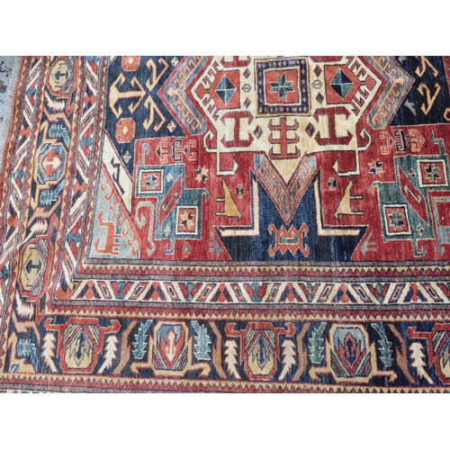 127 - Good quality carpet with geometric designs in mostly blue red and cream wools, 117x80ins approx